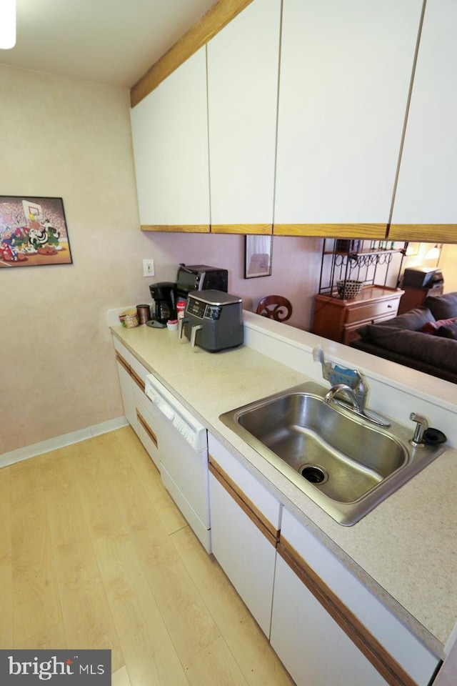 kitchen featuring white cabinetry, white dishwasher, sink, and light hardwood / wood-style flooring