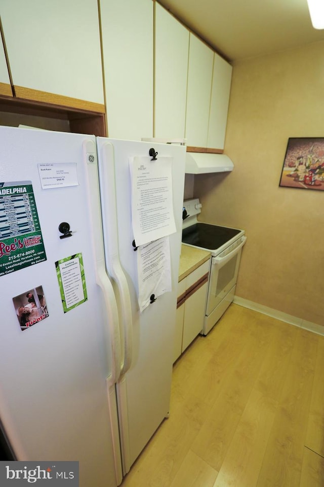 kitchen featuring white appliances, light hardwood / wood-style flooring, and white cabinets