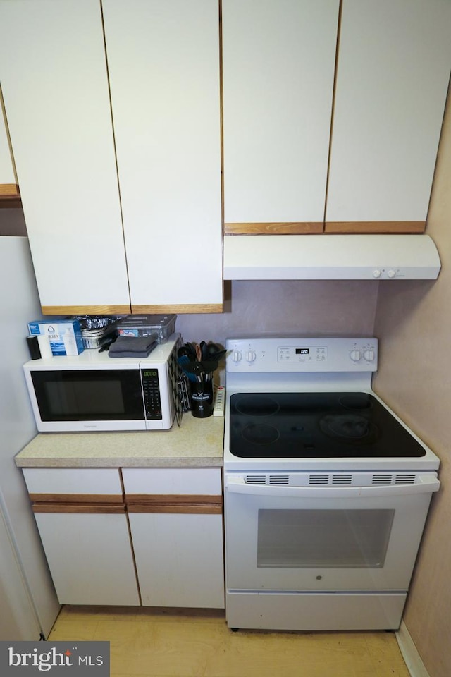 kitchen featuring white cabinetry and white appliances