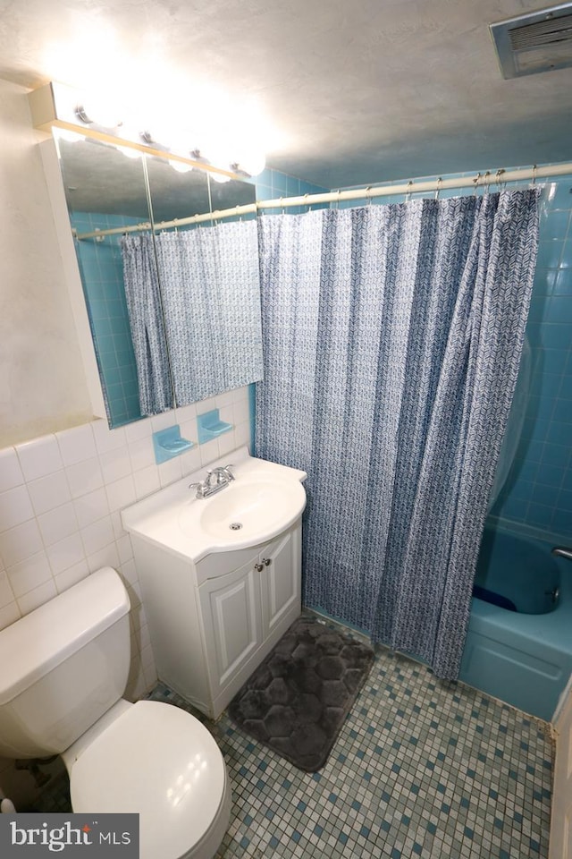 full bathroom featuring tile walls, tile patterned flooring, vanity, shower / tub combo, and toilet