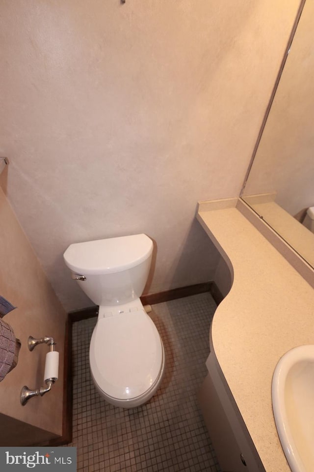 bathroom with tile patterned flooring, vanity, and toilet