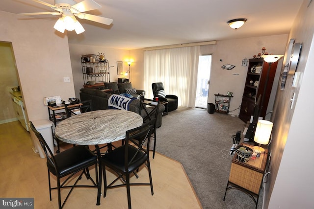 dining space featuring ceiling fan and light carpet