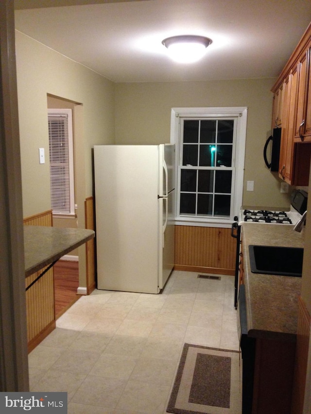 kitchen with wooden walls and white appliances