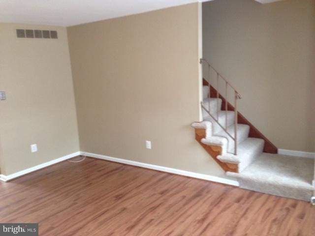 staircase with hardwood / wood-style flooring