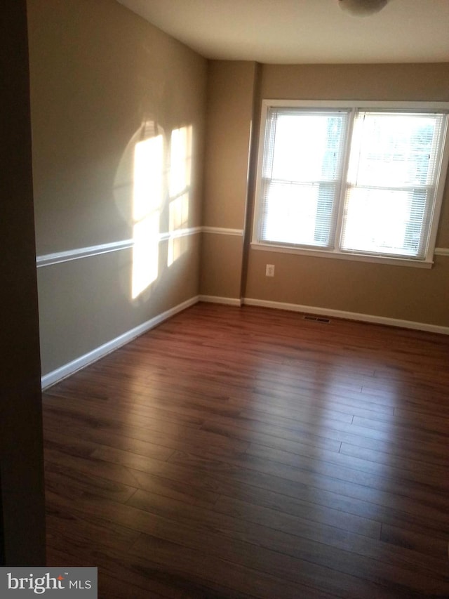 empty room with dark hardwood / wood-style floors