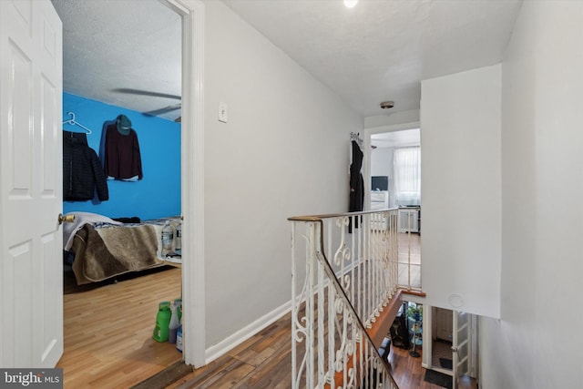 hallway with hardwood / wood-style flooring and a textured ceiling