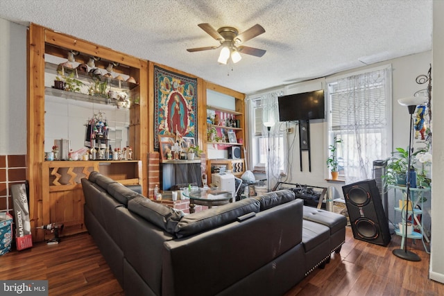 living room with dark hardwood / wood-style floors, a textured ceiling, and ceiling fan