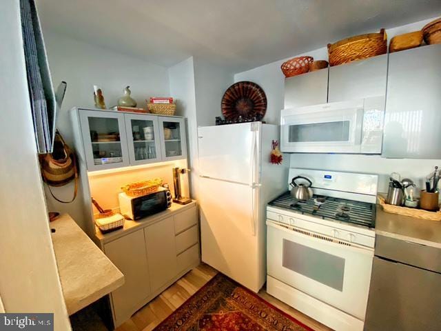 kitchen with white appliances and dark hardwood / wood-style floors