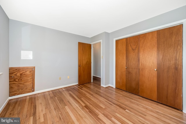 unfurnished bedroom with a closet and light hardwood / wood-style flooring