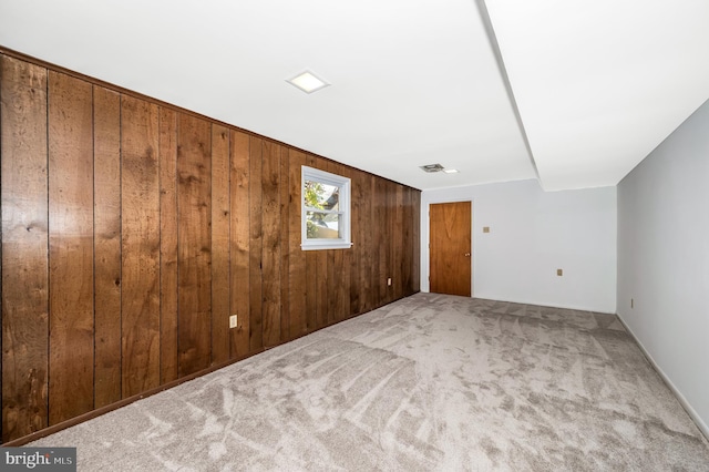 carpeted empty room with wooden walls