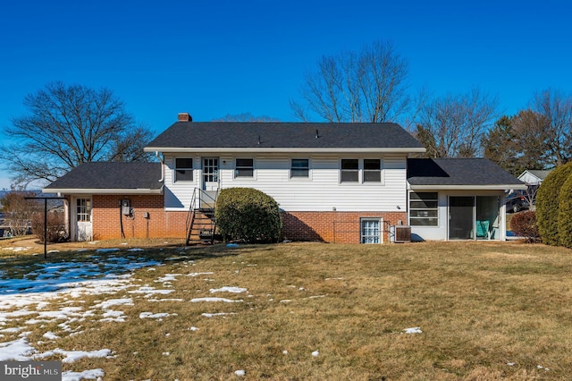 snow covered house with central AC unit, a yard, and a sunroom