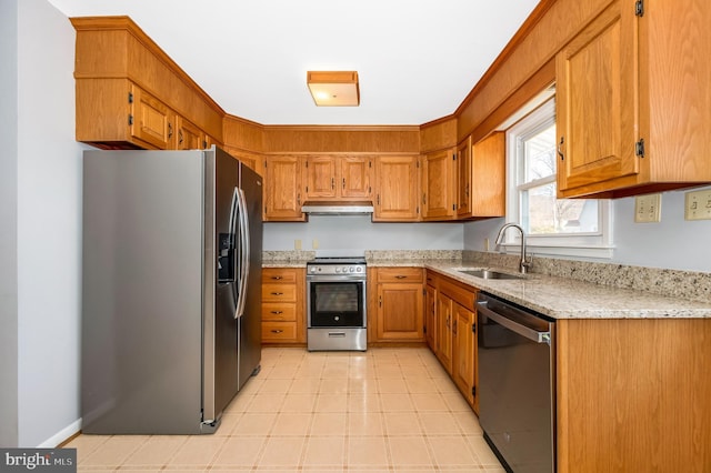 kitchen featuring stainless steel appliances, light stone countertops, and sink