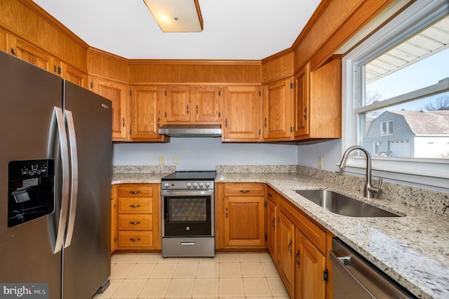 kitchen with light stone counters, appliances with stainless steel finishes, and sink