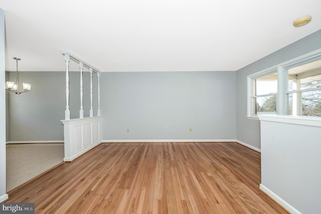 unfurnished room featuring a chandelier and light hardwood / wood-style floors