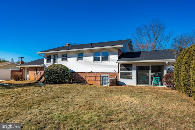 rear view of property with cooling unit, a lawn, and a sunroom