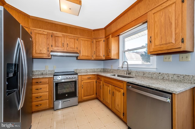 kitchen featuring appliances with stainless steel finishes, sink, and light stone counters