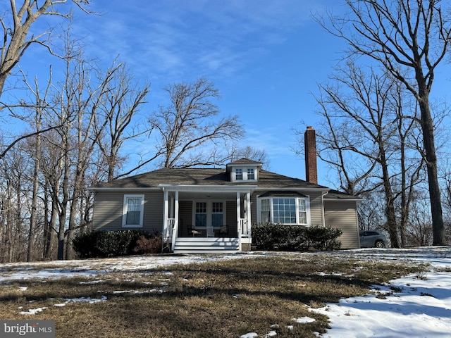 bungalow with covered porch and a chimney