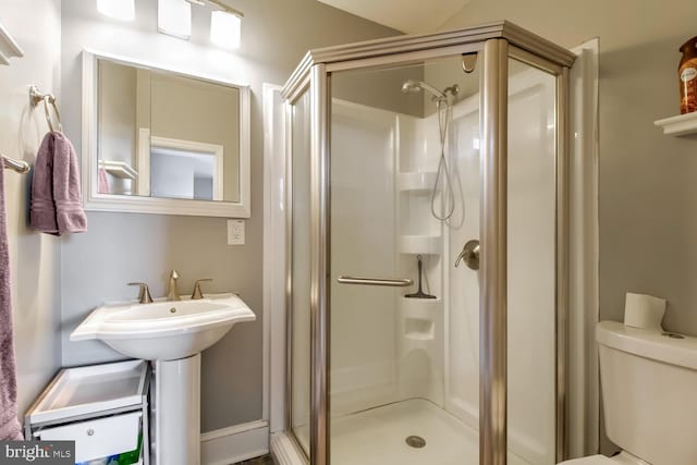 bathroom featuring a stall shower and toilet