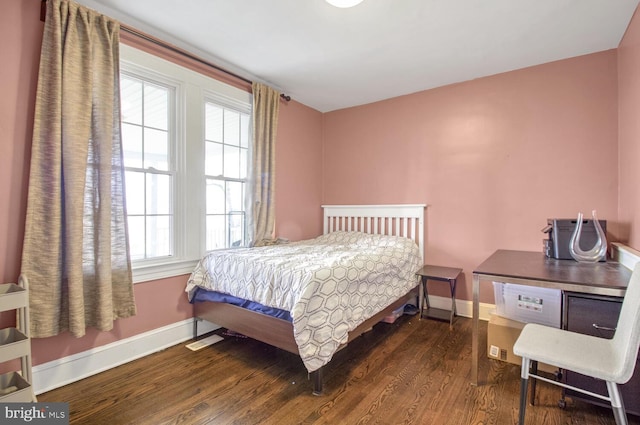 bedroom with baseboards and wood finished floors