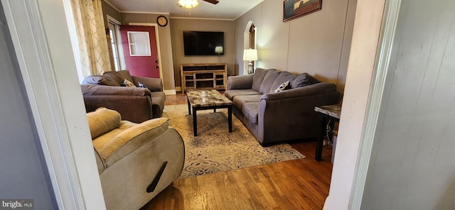 living room with ceiling fan, wood finished floors, and crown molding