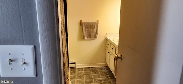 bathroom with a baseboard radiator, tile patterned flooring, vanity, and baseboards