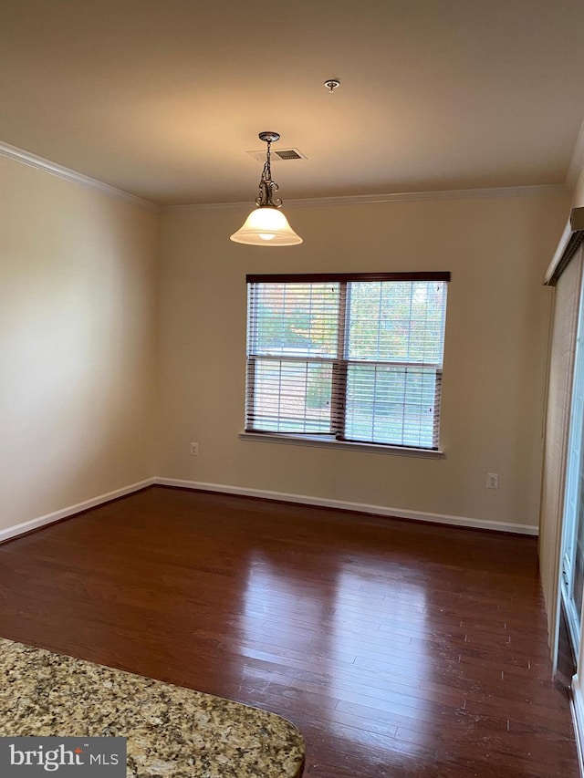 spare room with crown molding and dark wood-type flooring