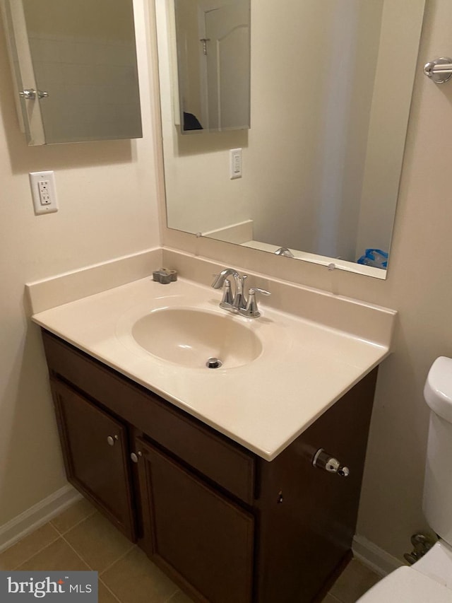 bathroom with vanity, toilet, and tile patterned flooring