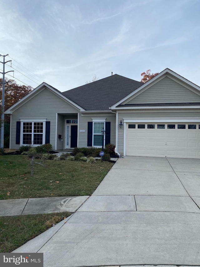 ranch-style home with a garage and a front lawn