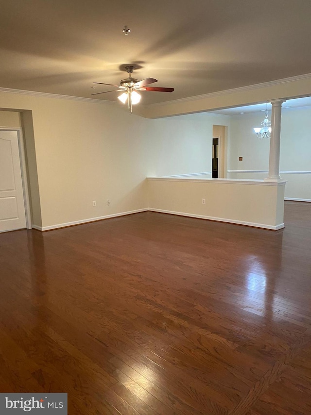 spare room featuring ornamental molding, dark hardwood / wood-style floors, ceiling fan with notable chandelier, and ornate columns