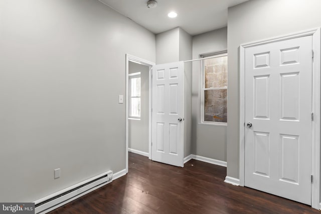 corridor with baseboard heating and dark wood-type flooring