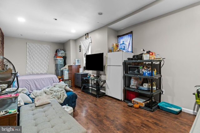 bedroom with white refrigerator and dark wood-type flooring