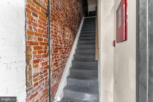 staircase with brick wall