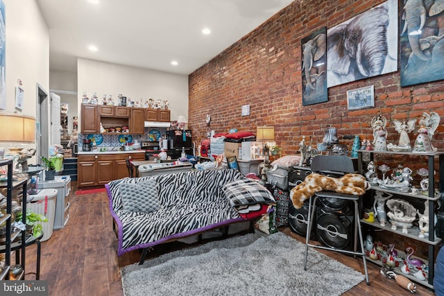 bedroom featuring brick wall and dark hardwood / wood-style flooring