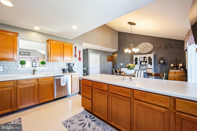 kitchen with vaulted ceiling, dishwasher, sink, and hanging light fixtures