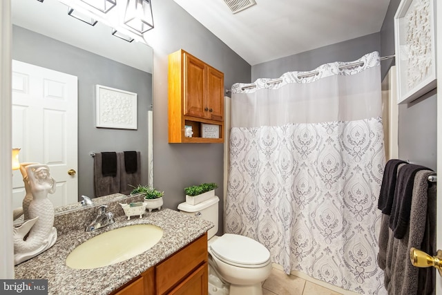 bathroom featuring tile patterned flooring, vanity, and toilet