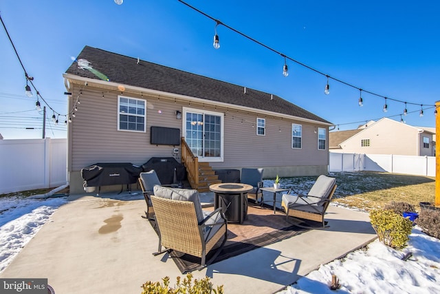 snow covered house featuring a patio and a fire pit