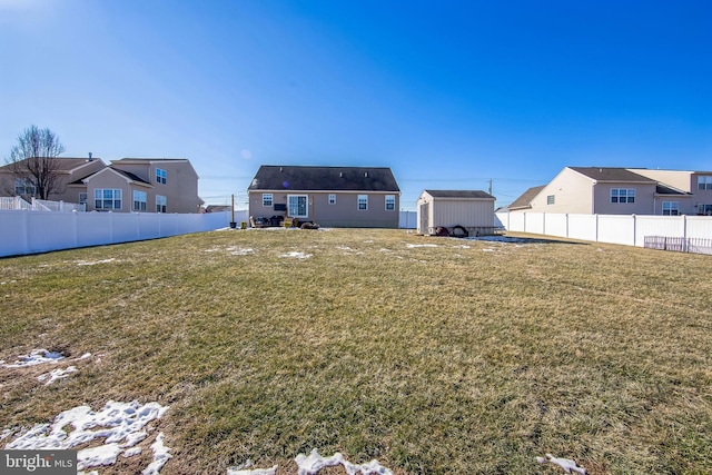 rear view of property featuring a storage unit and a lawn