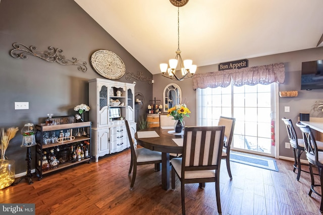 dining room featuring lofted ceiling, dark wood-type flooring, and an inviting chandelier