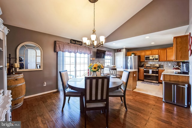 dining room featuring hardwood / wood-style flooring, a chandelier, and vaulted ceiling