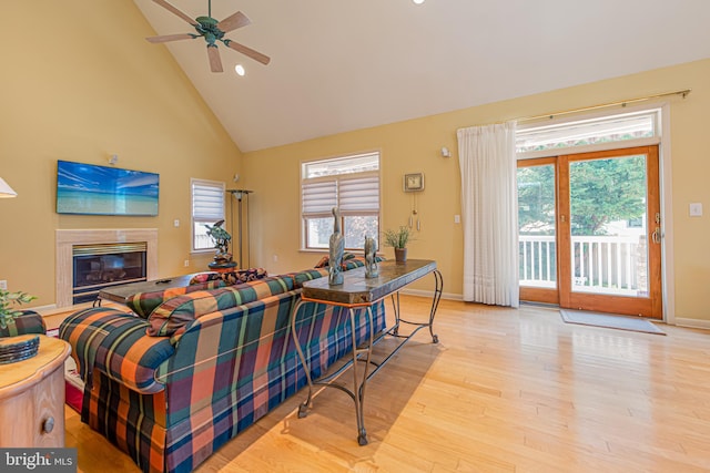 living room featuring high vaulted ceiling, a wealth of natural light, a high end fireplace, and light hardwood / wood-style floors