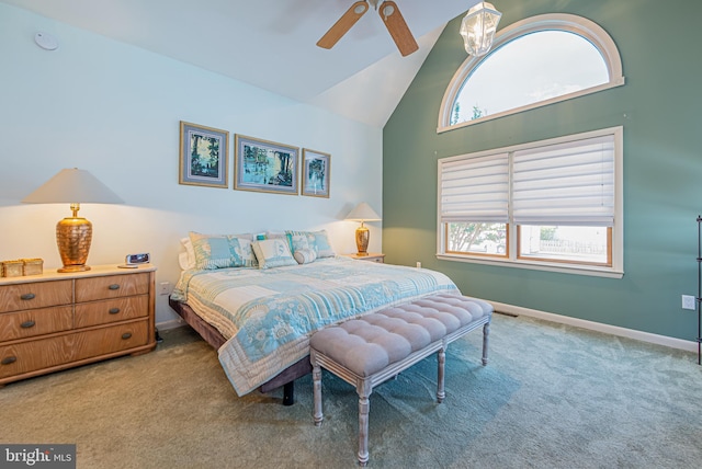 carpeted bedroom with ceiling fan and high vaulted ceiling