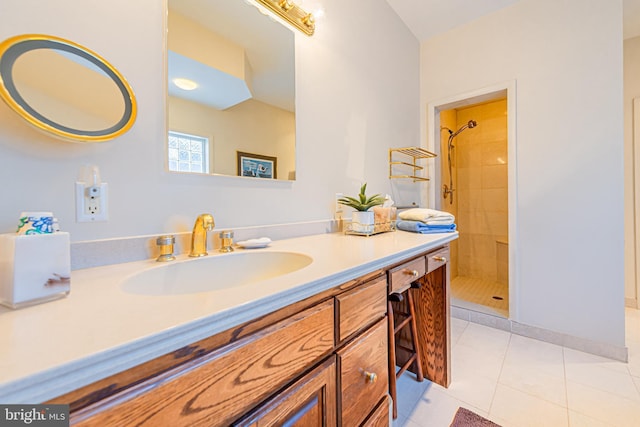 bathroom featuring vanity, a tile shower, and tile patterned floors