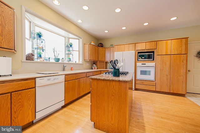 kitchen featuring appliances with stainless steel finishes, sink, a kitchen island, and light hardwood / wood-style flooring