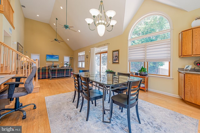 dining space with light hardwood / wood-style flooring, high vaulted ceiling, and a chandelier