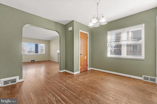 unfurnished dining area featuring wood-type flooring and a notable chandelier