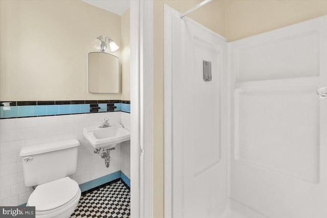 bathroom featuring tile walls, sink, and toilet