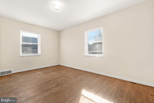 unfurnished room with hardwood / wood-style flooring