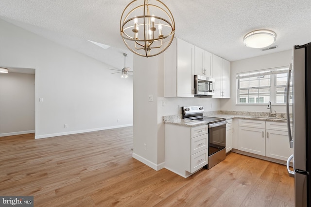 kitchen featuring stainless steel appliances, sink, hanging light fixtures, and white cabinets