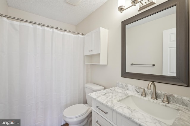 bathroom with vanity, a textured ceiling, and toilet