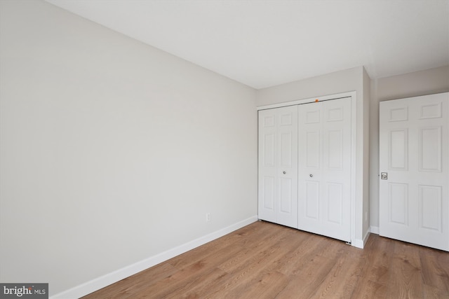 unfurnished bedroom with a closet and light hardwood / wood-style flooring